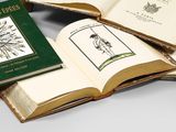 several open books sitting on top of each other on top of a table