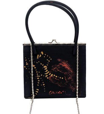 un sac à main noir orné de fleurs noires et dorées