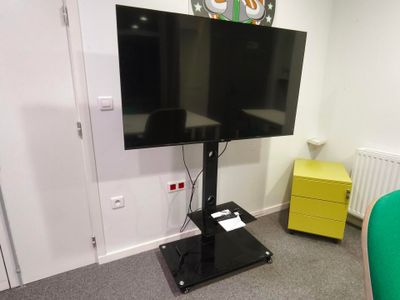 un téléviseur à écran plat sur un support dans le coin d'une pièce