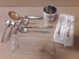 une table sur laquelle sont posés des couverts et des cuillères en argent