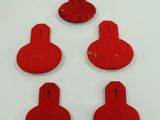 six pieces of red plastic are arranged in a row on a white surface