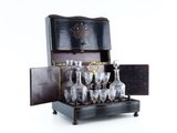 bottles and glasses in a wooden case on a white surface