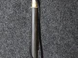 a small metal pole with a metal handle on a black surface
