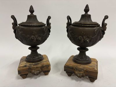 paire d'urnes anciennes en bronze reposant sur des socles en bois