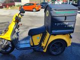 a yellow scooter with a box on the back of it