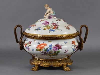 un bol recouvert de blanc et d'or, surmonté d'une statuette