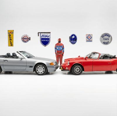 a man standing in front of two cars next to each other