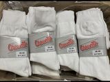 four pairs of white socks are in a box on a table