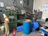 a blue barrel sitting next to a machine in a garage