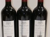 three bottles of red wine are lined up on a table