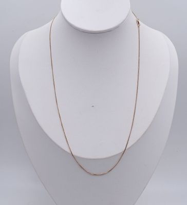 a white mannequin with a gold chain on it
