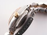 a close up of a watch on a white surface
