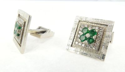 une paire de boutons de manchette en émeraude et diamant sur fond blanc