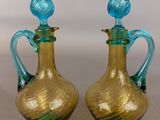 pair of blue and green glass vases sitting on top of a table
