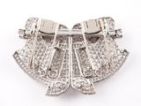 a silver brooch on a white surface with a white background