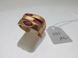 une image représentant une bague en or sertie de pierres roses sur un fond blanc
