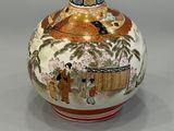 a vase with a painting on it sitting on a table