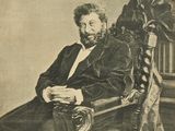 portrait of a man sitting in a chair with a book in his lap