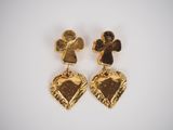 a pair of gold toned heart shaped earrings with an angel and cross