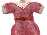 une robe posée sur un mannequin, avec une ceinture rouge