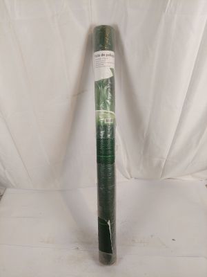 un rouleau de plastique vert est posé sur une surface blanche