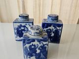 three blue and white vases sitting on a table