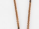 collier de perles marron orné d'une pièce de monnaie sur fond blanc