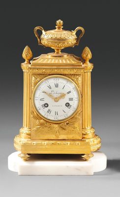 une horloge en or surmontée d'un oiseau