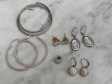 several pieces of silver jewelry on a marble counter top