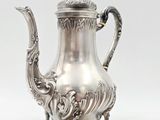 silver plated tea pot with ornate decoration on stand