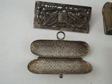 three pieces of antique silverware are displayed on a white surface