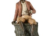 une statue représentant un homme assis sur une souche d'arbre