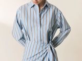the woman is wearing a blue and white striped shirt dress