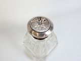 une petite salière en verre avec un couvercle en argent