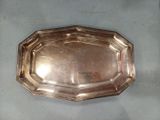 un plat en argent ancien posé sur une table, sur fond blanc