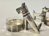 a silver dog figurine next to a glass of water