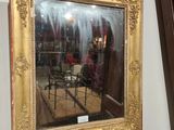 un miroir accroché au mur au-dessus d'une chaise