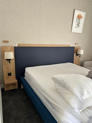 un lit avec des draps et des oreillers blancs dans une chambre