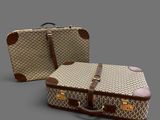 two pieces of luggage sitting next to each other on a gray surface