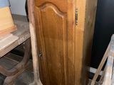 une armoire en bois et une chaise dans un coin de la pièce