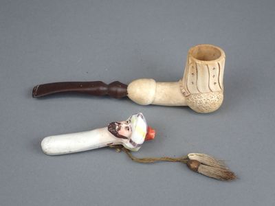 une petite pipe et un petit porte-pipe posés sur une table