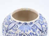 a blue and white vase sitting on a white surface