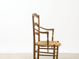 a wooden chair with a woven seat in a white room
