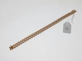 Gros plan sur un bracelet en chaîne en or portant une étiquette