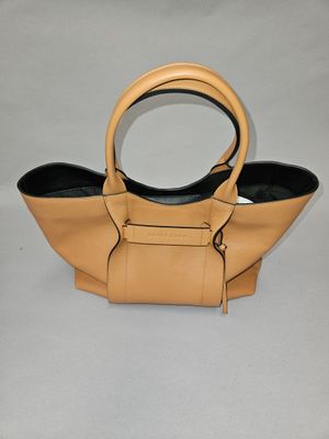 beige leather handbag with black handles on a white background