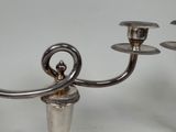 a silver candelier that has three candles on it