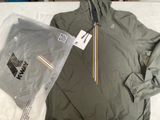 une veste et un sweat à capuche Nike dans un sac en plastique posé sur un lit