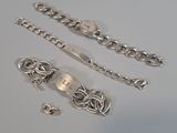 a silver bracelet and a silver chain on a table