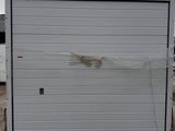 a picture of a white garage door on a pallet in a parking lot