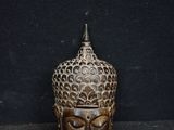 a wooden statue of a buddha head on a black surface